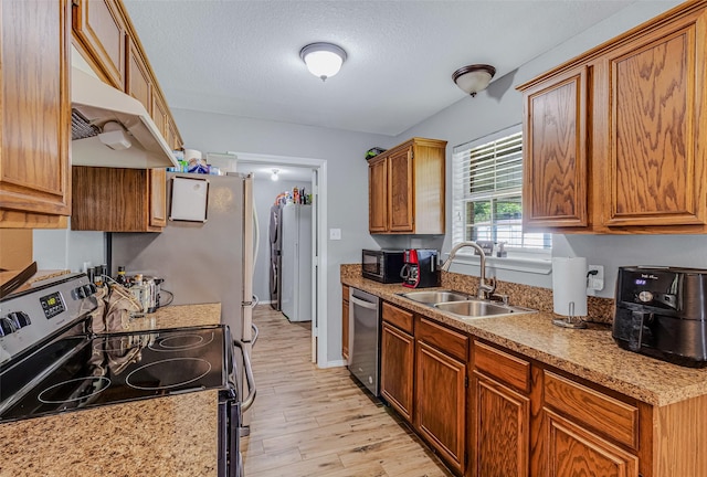 kitchen featuring a textured ceiling, stainless steel appliances, light hardwood / wood-style floors, and sink