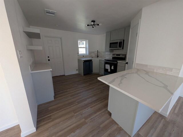 kitchen with kitchen peninsula, appliances with stainless steel finishes, backsplash, and white cabinets