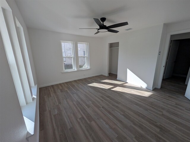 unfurnished bedroom with ceiling fan, a closet, and dark wood-type flooring