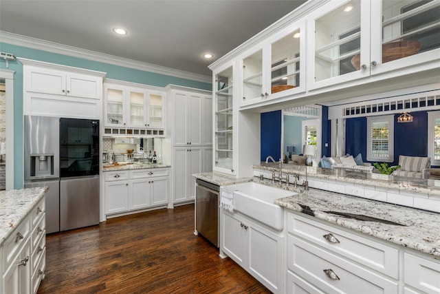 kitchen featuring white cabinets, crown molding, sink, appliances with stainless steel finishes, and dark hardwood / wood-style flooring