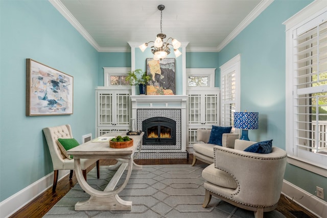 living area featuring a tiled fireplace, crown molding, a chandelier, and dark hardwood / wood-style floors