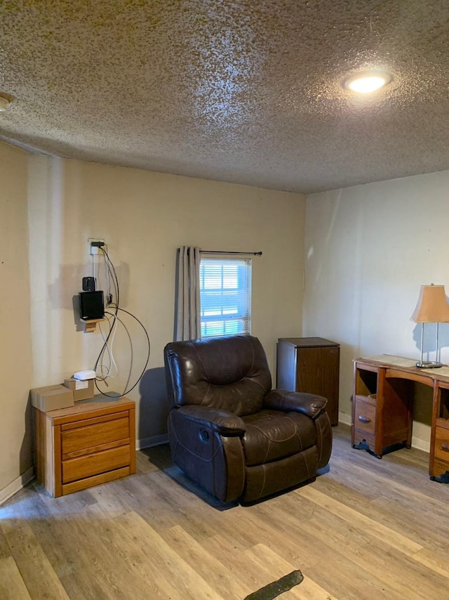 sitting room featuring light hardwood / wood-style floors and a textured ceiling