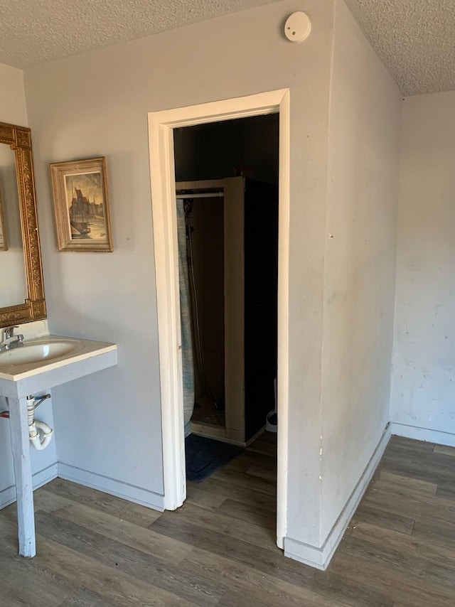 bathroom with hardwood / wood-style floors and a textured ceiling