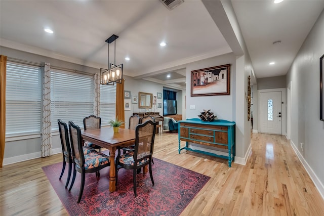 dining room featuring a chandelier, light hardwood / wood-style floors, and ornamental molding