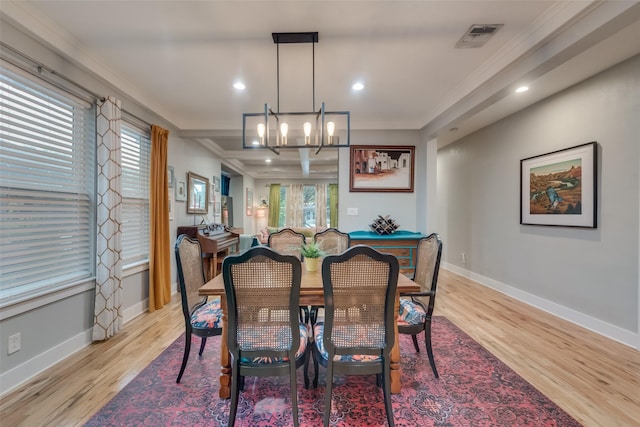 dining area featuring light hardwood / wood-style floors, ornamental molding, and a notable chandelier