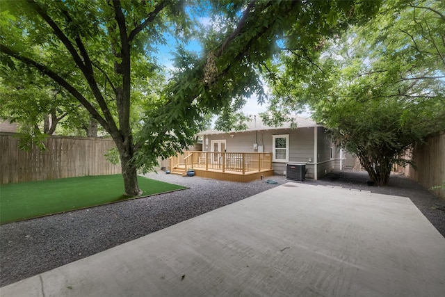 back of property featuring cooling unit, a wooden deck, a lawn, and a patio