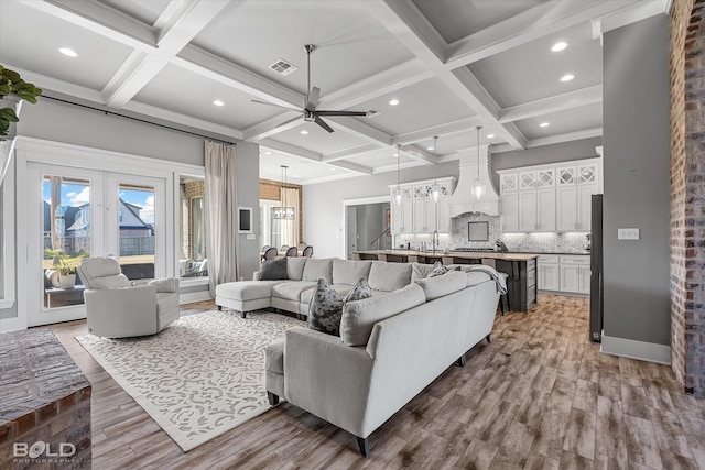 living room featuring beam ceiling, hardwood / wood-style flooring, and coffered ceiling