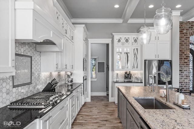 kitchen with pendant lighting, dark stone counters, white cabinets, sink, and appliances with stainless steel finishes