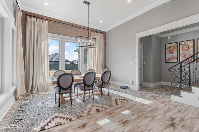 dining space featuring crown molding, light hardwood / wood-style floors, and a notable chandelier