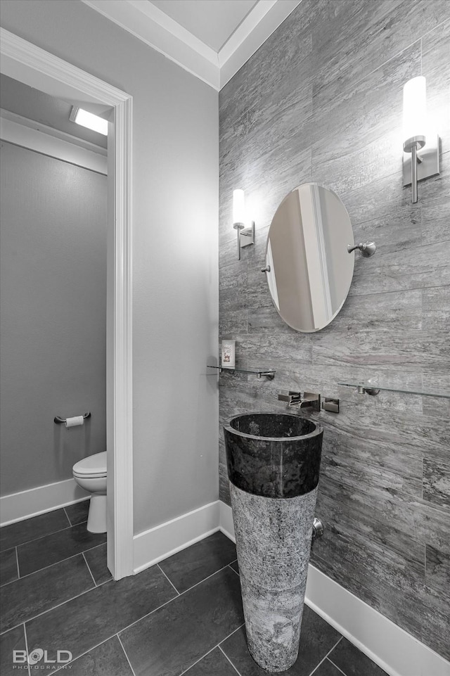 bathroom featuring tile patterned flooring, tile walls, and toilet