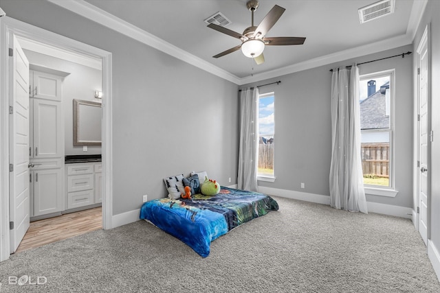 bedroom with crown molding, light colored carpet, connected bathroom, and ceiling fan