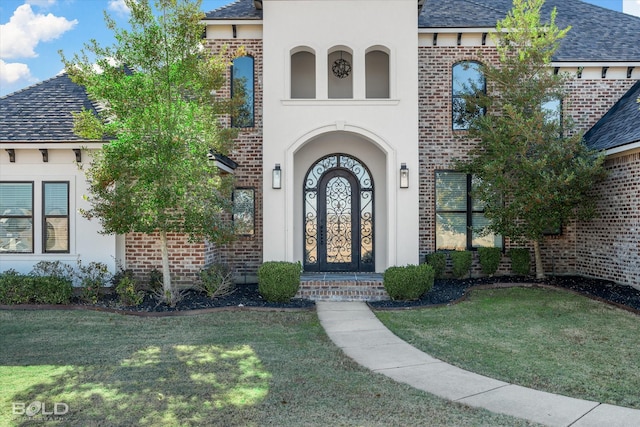 view of exterior entry with a yard