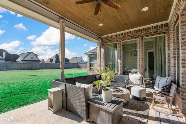 view of patio with ceiling fan and an outdoor living space with a fire pit