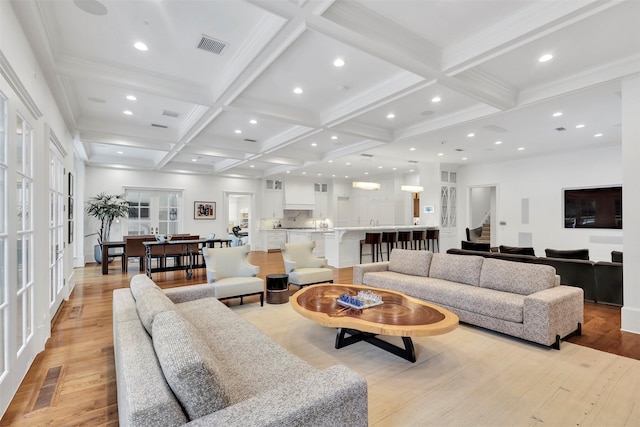 living room with beamed ceiling, light hardwood / wood-style floors, coffered ceiling, and french doors