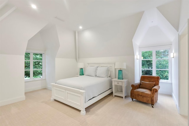 bedroom featuring lofted ceiling, light carpet, and multiple windows