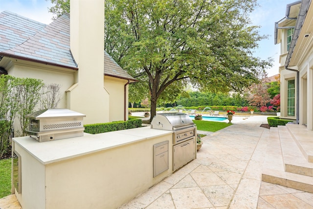 view of patio / terrace featuring pool water feature, area for grilling, and a grill