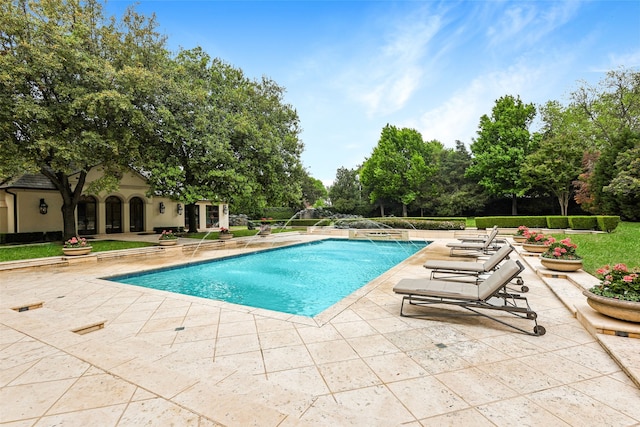 view of swimming pool with pool water feature and a patio