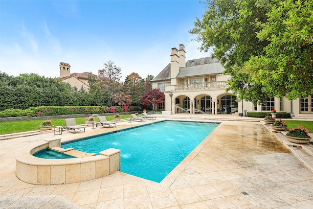 view of pool with a patio, pool water feature, and an in ground hot tub