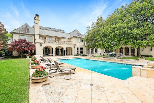 view of swimming pool with a patio area, pool water feature, and a yard