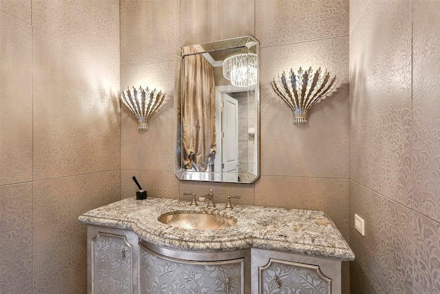 bathroom featuring vanity and tile walls