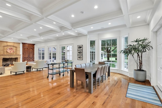 dining room with coffered ceiling, beam ceiling, and light hardwood / wood-style flooring