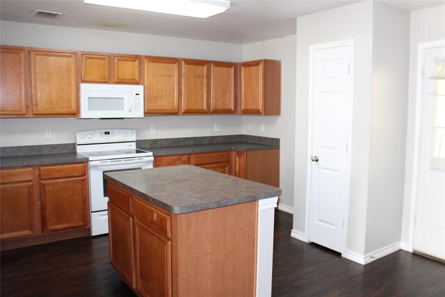 kitchen featuring dark hardwood / wood-style floors, a center island, and white appliances