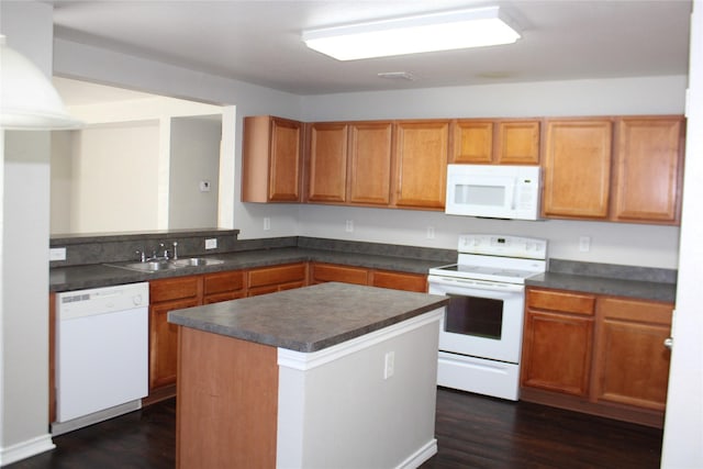 kitchen featuring sink, a center island, dark hardwood / wood-style flooring, kitchen peninsula, and white appliances