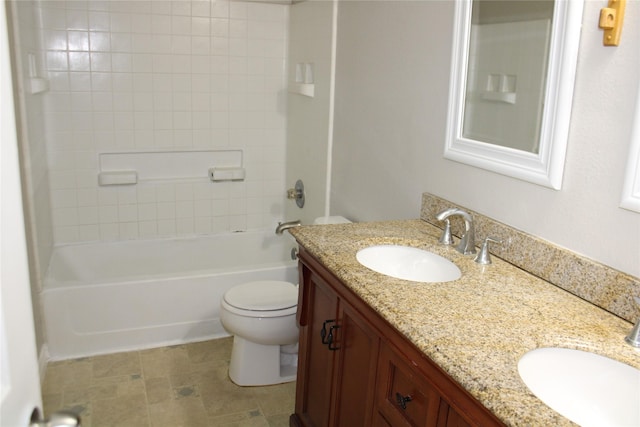 full bathroom featuring tiled shower / bath, vanity, and toilet