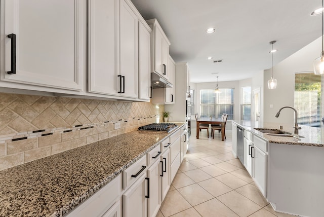 kitchen with pendant lighting, white cabinetry, a wealth of natural light, and sink