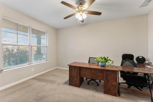 carpeted office space with ceiling fan