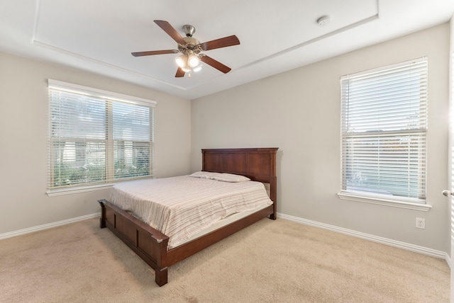 carpeted bedroom featuring ceiling fan and multiple windows