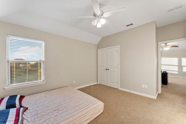 carpeted bedroom featuring ceiling fan, a closet, lofted ceiling, and multiple windows