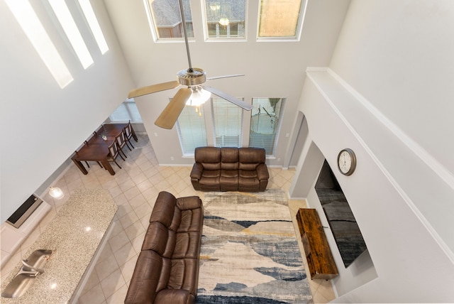 living room featuring a towering ceiling and ceiling fan