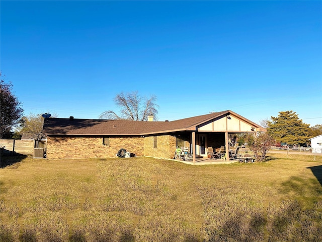 rear view of property with a patio, central AC unit, and a lawn