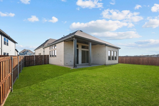 rear view of house featuring a lawn and a patio area