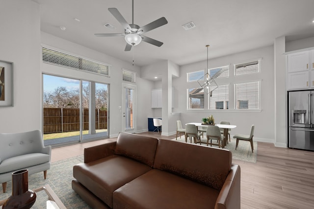 living room with ceiling fan, light hardwood / wood-style floors, and a wealth of natural light