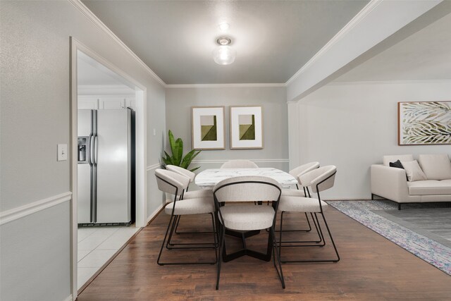 dining room with hardwood / wood-style flooring and crown molding