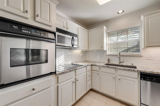 kitchen featuring backsplash, white cabinetry, sink, and stainless steel appliances