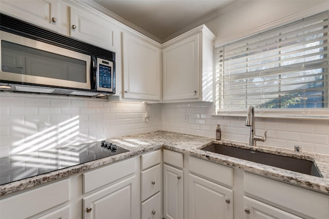 kitchen with white cabinets, backsplash, and sink