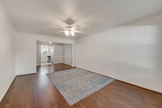 empty room featuring ceiling fan, dark hardwood / wood-style flooring, and crown molding