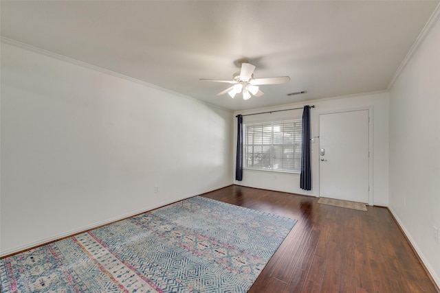 spare room featuring ceiling fan, dark wood-type flooring, and ornamental molding