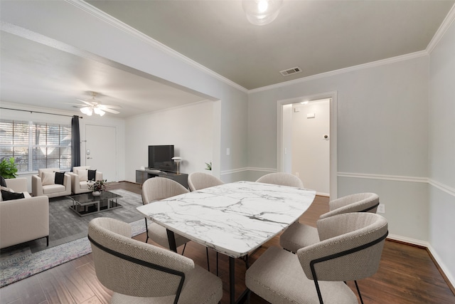 dining space featuring crown molding, dark wood-type flooring, and ceiling fan