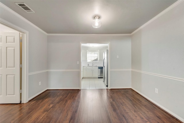 empty room featuring dark hardwood / wood-style flooring, ornamental molding, and sink