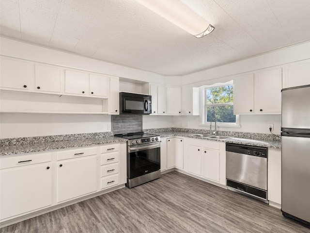 kitchen with dark hardwood / wood-style floors, white cabinetry, sink, stainless steel appliances, and light stone countertops