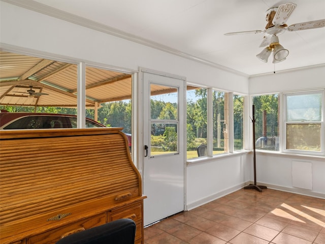 unfurnished sunroom with lofted ceiling with beams, wooden ceiling, ceiling fan, and a healthy amount of sunlight