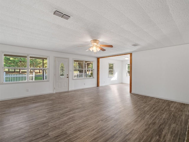 unfurnished room with ceiling fan, dark wood-type flooring, and a textured ceiling