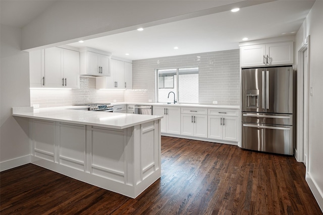 kitchen featuring a peninsula, white cabinetry, stainless steel appliances, and light countertops