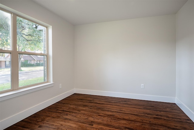 unfurnished room featuring dark wood-type flooring and a wealth of natural light