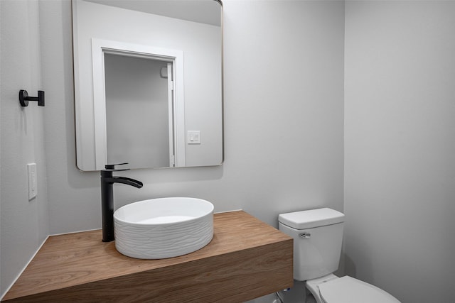 bathroom with toilet, a sink, and wood finished floors