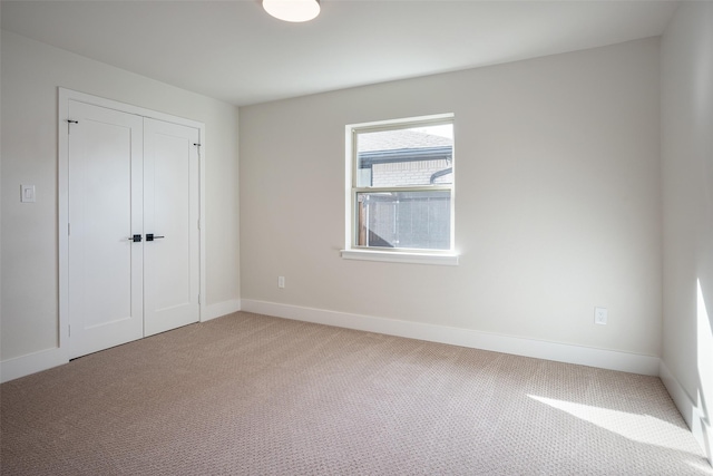 unfurnished bedroom with carpet floors, baseboards, and a closet